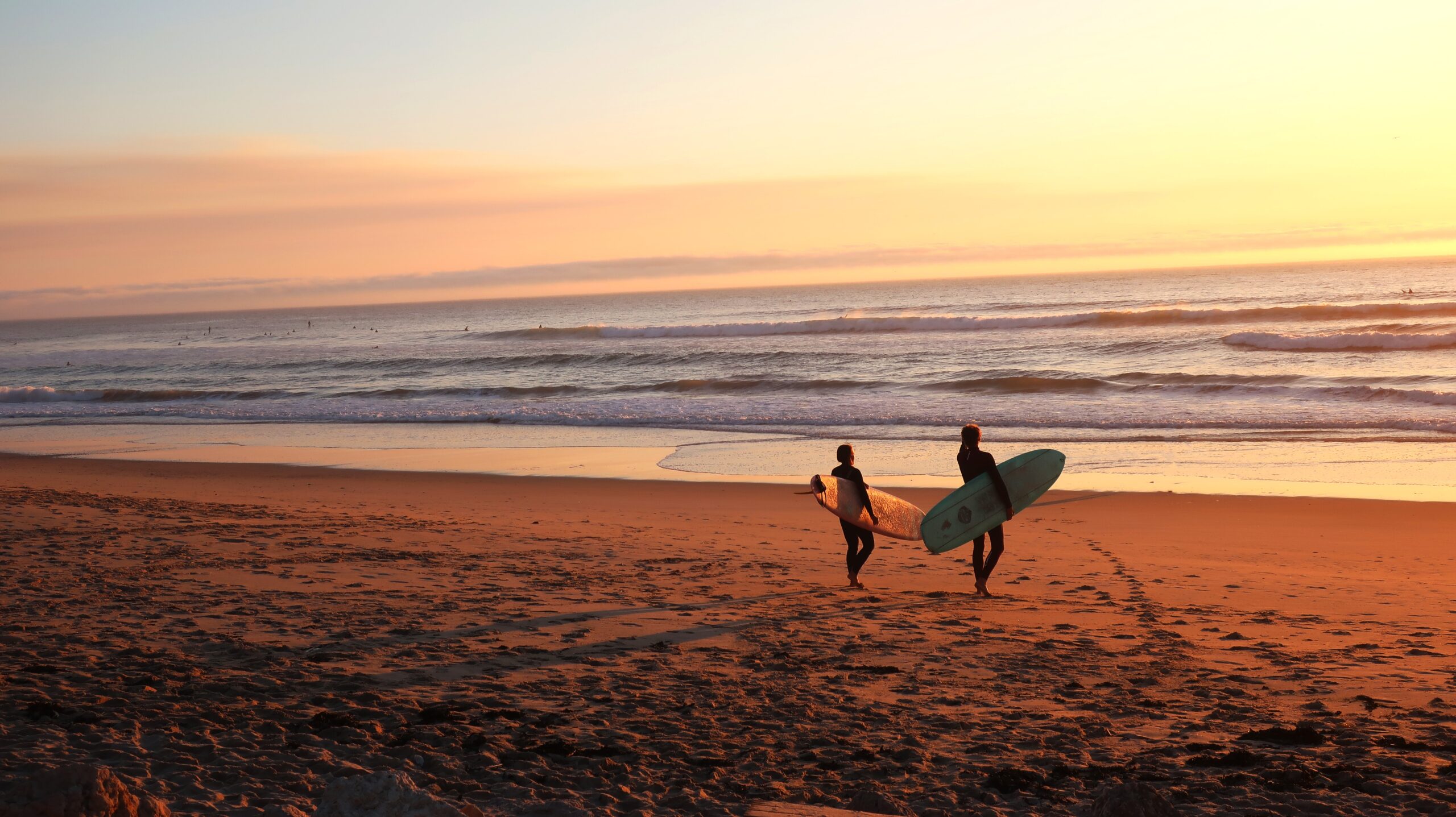 two surfers on empty beach